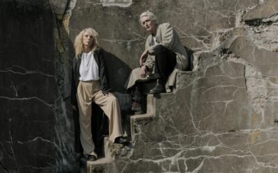 a man and woman sitting on concrete stairs