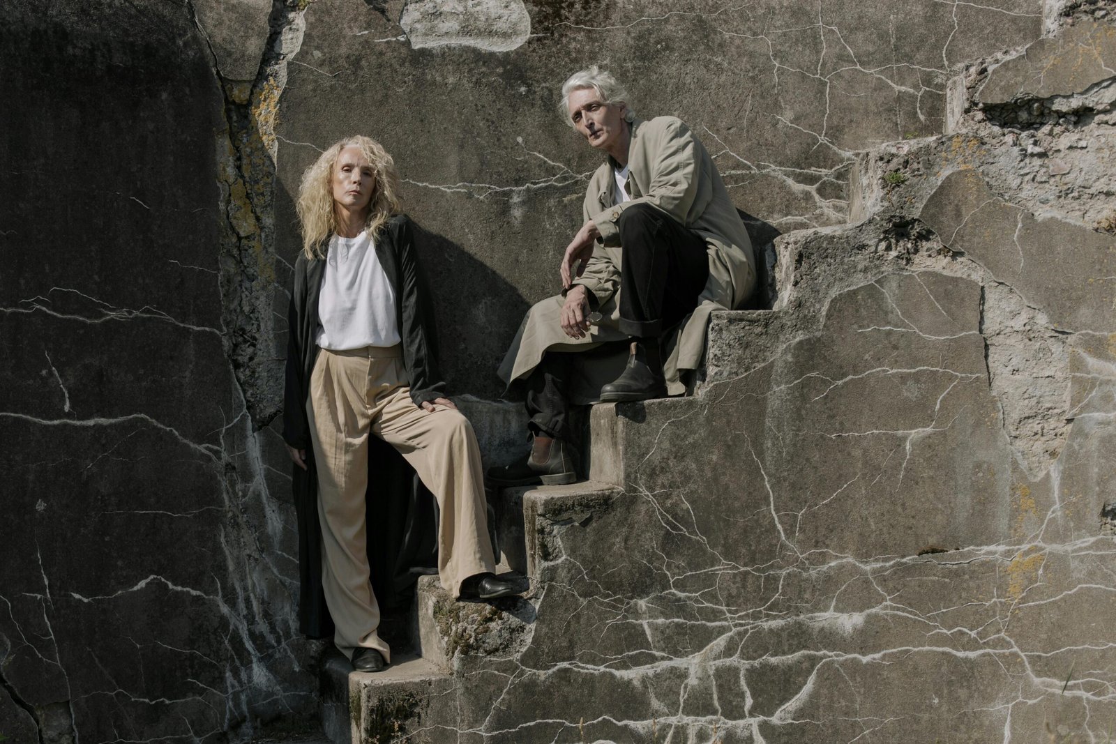 a man and woman sitting on concrete stairs