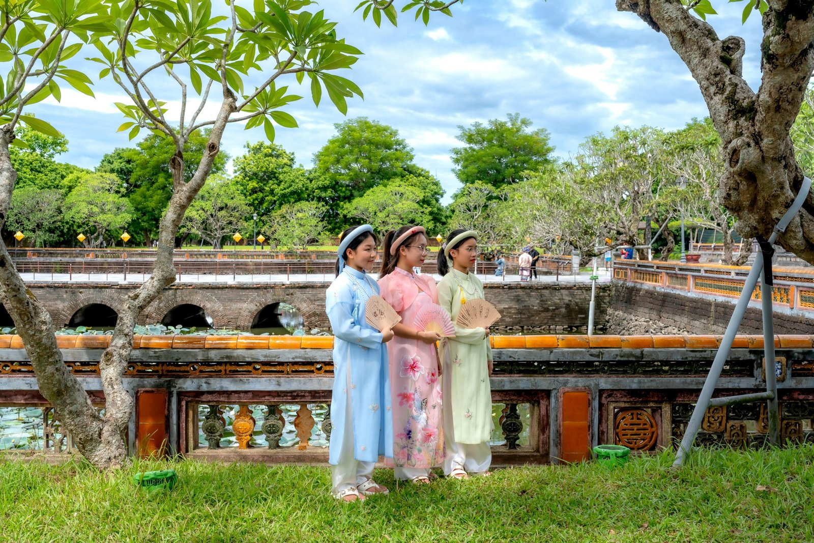 a group of girls wearing traditional dresses standing on grass