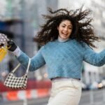 a woman holding shopping bags and smiling