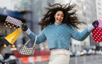 a woman holding shopping bags and smiling